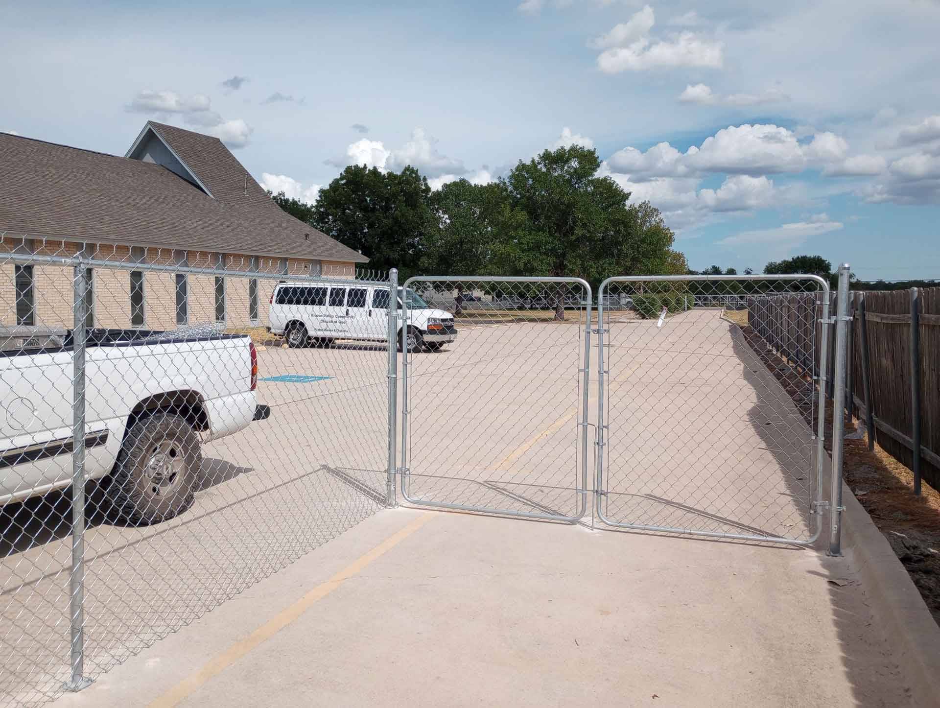 A chain link fence, blocking off a section of a parking lot